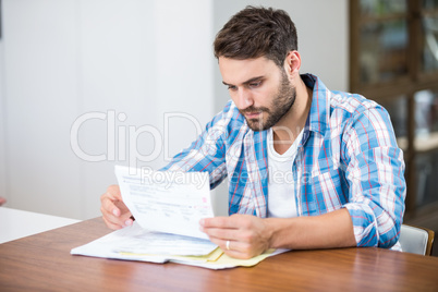 Man reading documents while sitting at table