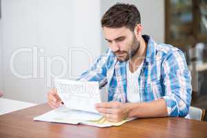 Man reading documents while sitting at table