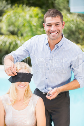 Portrait of smiling man blindfolding woman