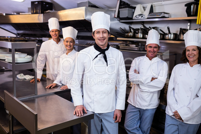 Happy chefs team standing together in commercial kitchen