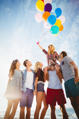 Friends posing with balloon on sand