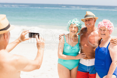 Senior man taking picture of his friends