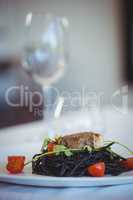 Squid ink spaghetti dish with basil