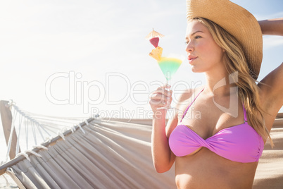 Woman drinking cocktail in hammock