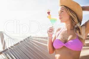 Woman drinking cocktail in hammock