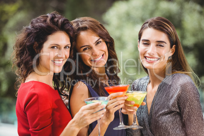 Beautiful female friends holding cocktails