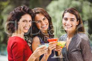 Beautiful female friends holding cocktails