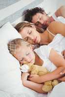 High angle view of parents sleeping with daughter