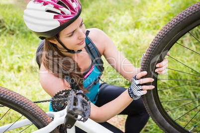 Woman fixing her bike