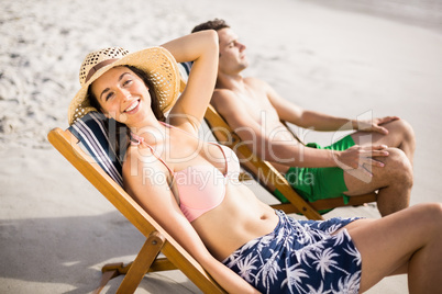 Young couple relaxing on armchair on the beach