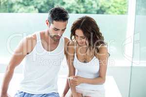 Woman showing pregnancy test to husband