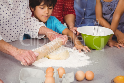 Grandmother with grandchildren using rolling pin