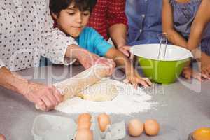 Grandmother with grandchildren using rolling pin