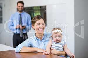Woman with daughter while man standing in background