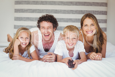Smiling family resting on bed Smiling family resting on bed