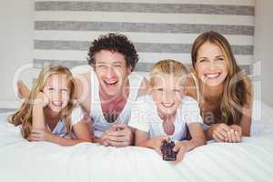 Smiling family resting on bed