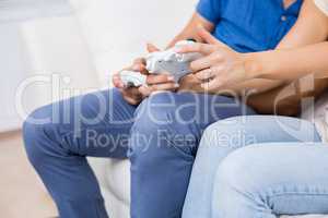 Mid section of couple playing video game