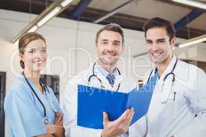 Portrait of smiling male doctors holding clipboards while workin
