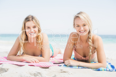 Portrait of two pretty women lying on the beach