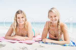 Portrait of two pretty women lying on the beach