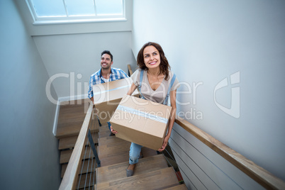 High angle view of smiling couple holding cardboard boxes while