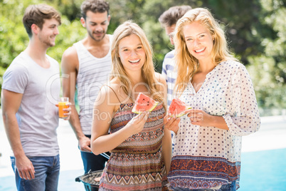 Young women smiling and having a slice of water melon