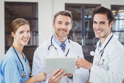 Portrait of smiling doctors holding digital tablet