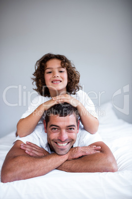 Portrait of a son lying on fathers back