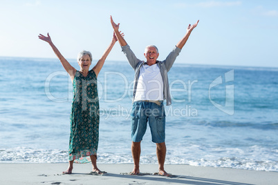 Senior couple raising arms