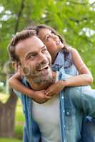 Father giving piggyback ride to daughter