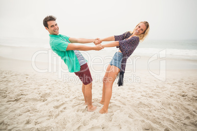 Portrait of happy couple holding hands on the beach