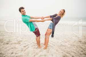Portrait of happy couple holding hands on the beach