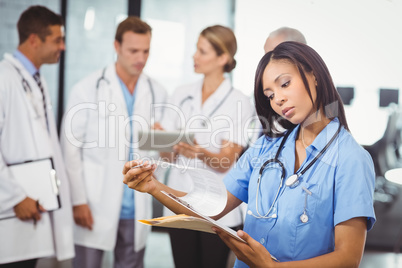 Female doctor looking at clipboard