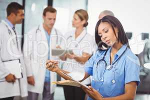 Female doctor looking at clipboard