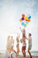 Portrait of friends holding balloon