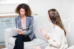 Woman explaining problems to psychologist at home