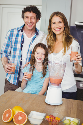 Portrait of smiling family with fruit juice