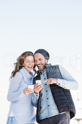 Happy young couple using mobile phone