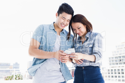 Happy young couple using mobile phone