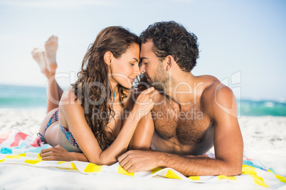 Couple lying on a towel at the beach