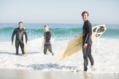 Portrait of surfer friends with surfboard standing on the beach