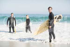 Portrait of surfer friends with surfboard standing on the beach