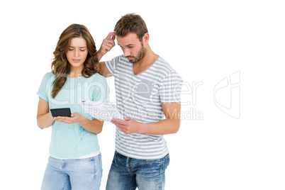 Worried couple calculating bill on calculator