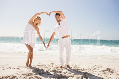 Smiling young couple doing heart shape