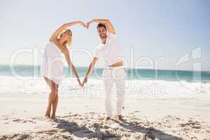 Smiling young couple doing heart shape