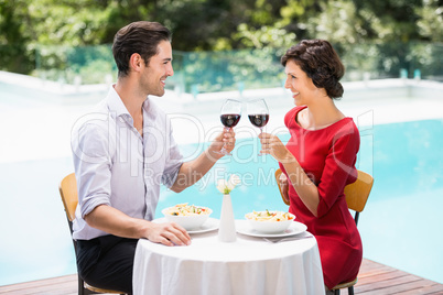 Smiling couple toasting red wine