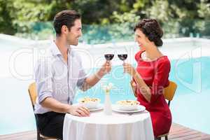 Smiling couple toasting red wine