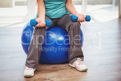 Low section of woman holding dumbbell