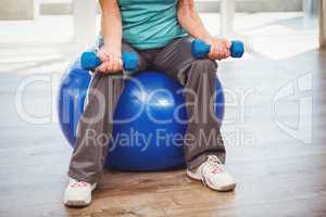 Low section of woman holding dumbbell