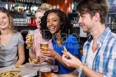 Happy friends having a drink and pizza